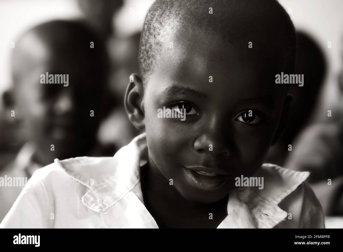 junger Afrikaner sitzt in Kenia in einem Klassenzimmer zum lernen Stock Photo