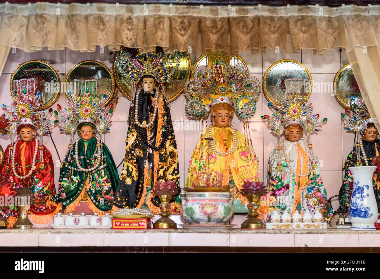 Shrine in local market, with 5 elements, red = fire, green = wood, yellow = earth, white = metal, black = water, Tallest = Buddha,  Ho Chi Min City, S Stock Photo