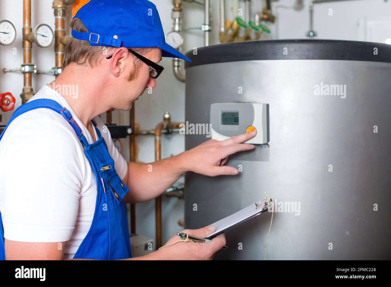 Engineer controlling the heating pipes at the boiler room Stock Photo ...