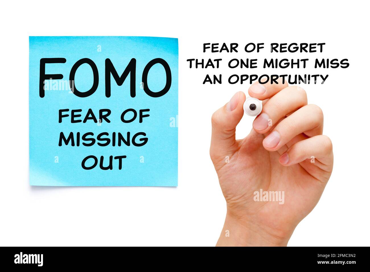 Hand writing a concept about Fear Of Missing Out - FOMO social anxiety disorder. Fear of regret that one might miss an opportunity. Stock Photo