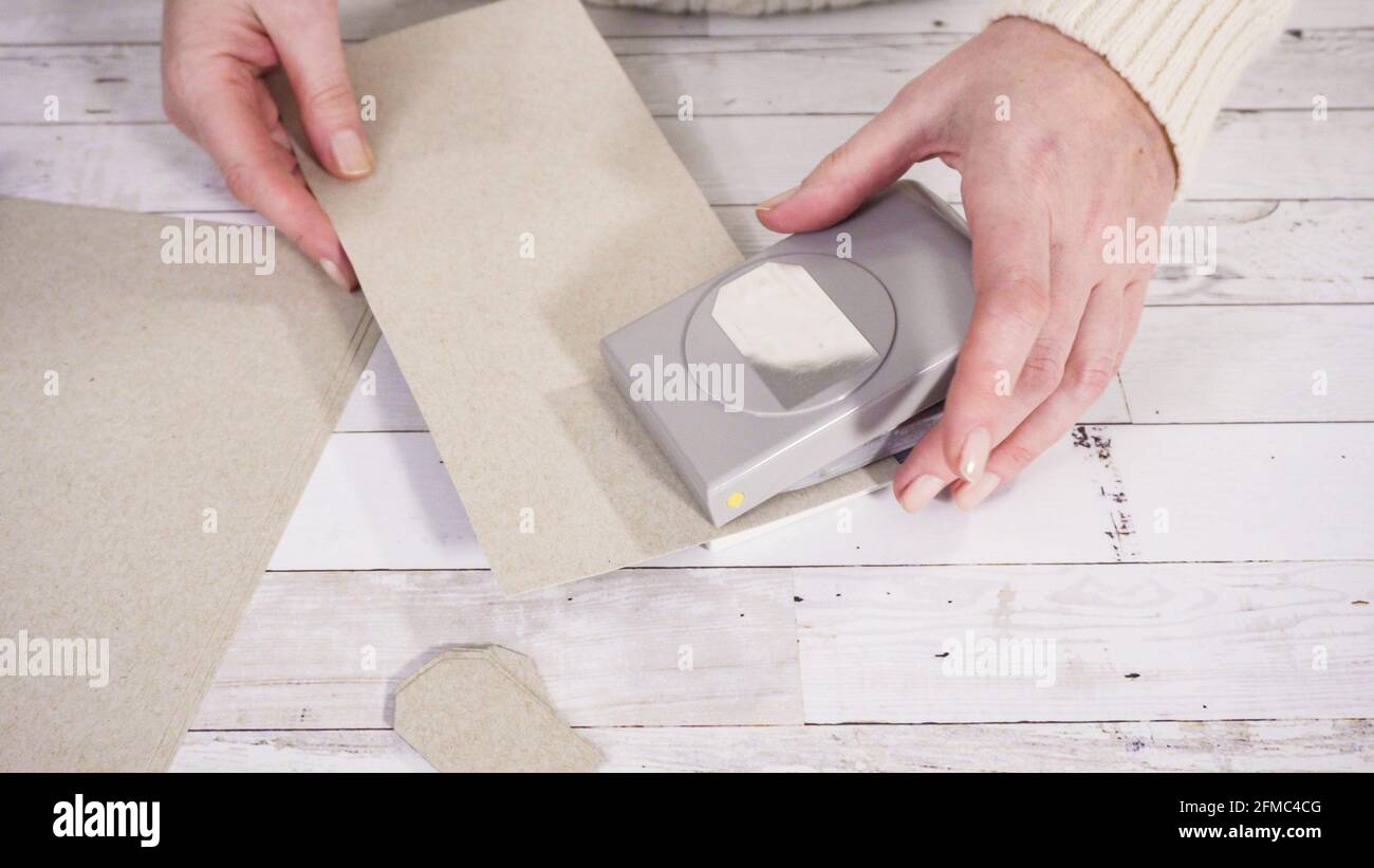 Step by step. Cutting out gift tags from brown paper with a paper punch  Stock Photo - Alamy