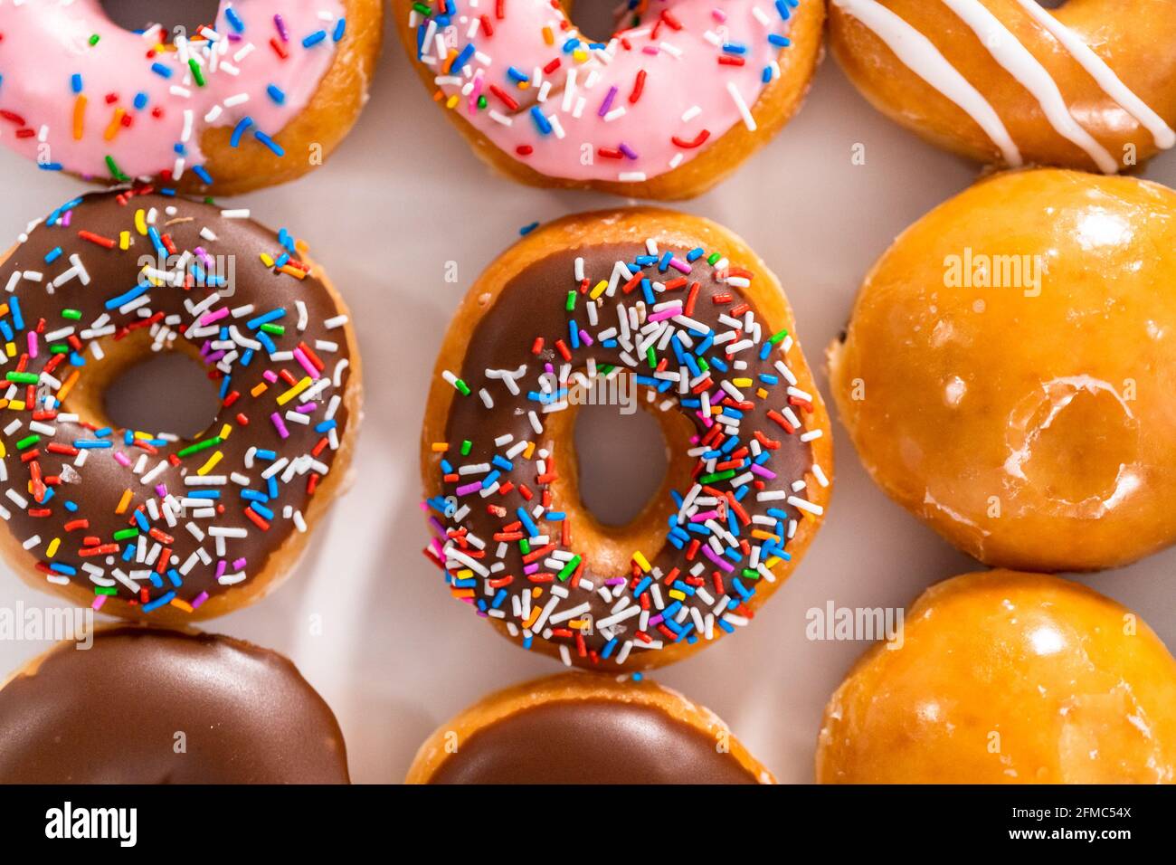 Variety of store-bought doughnuts in a white paper box Stock Photo - Alamy