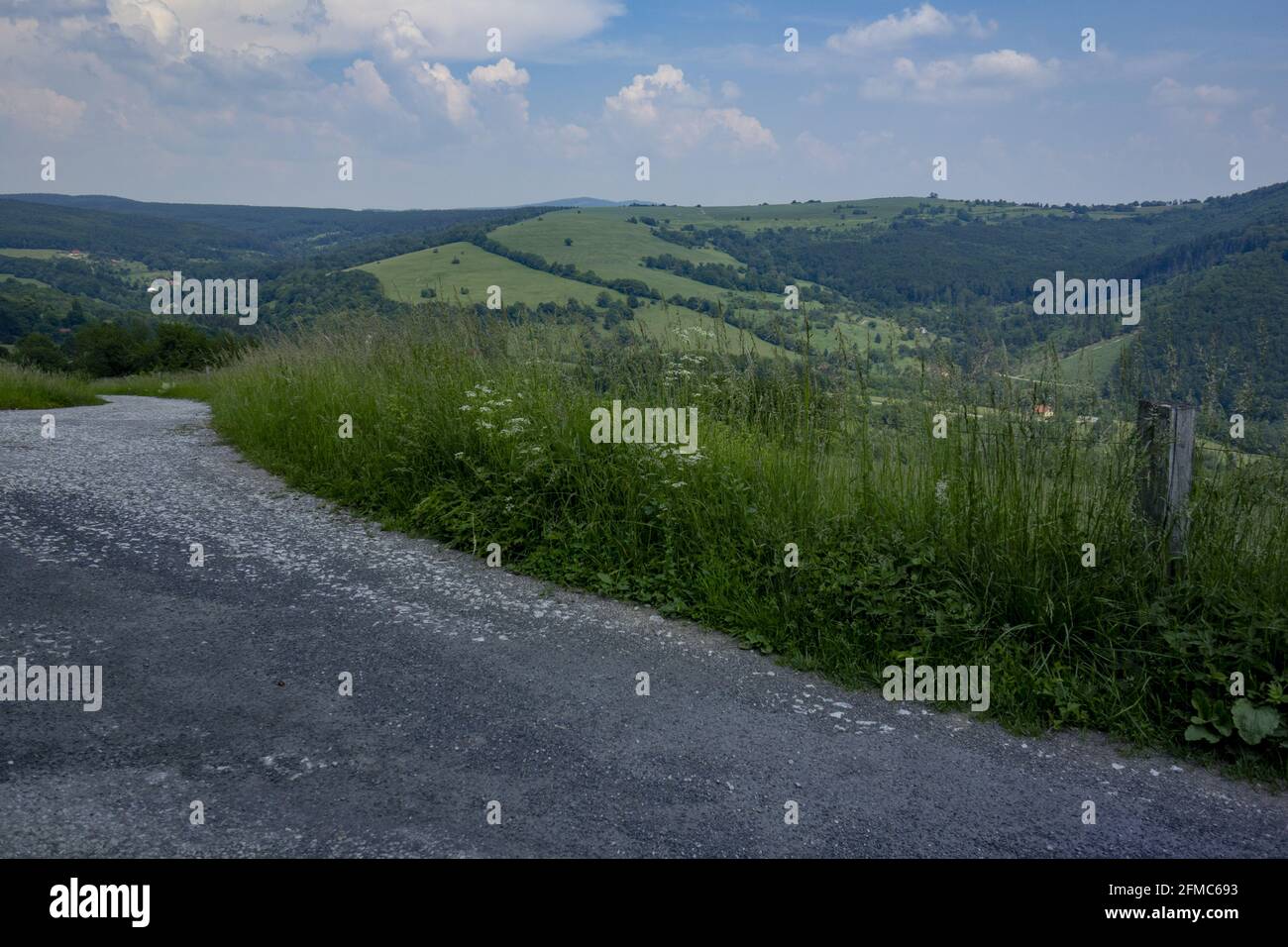 Route surrounded by fields and hills on a cloudy day Stock Photo - Alamy