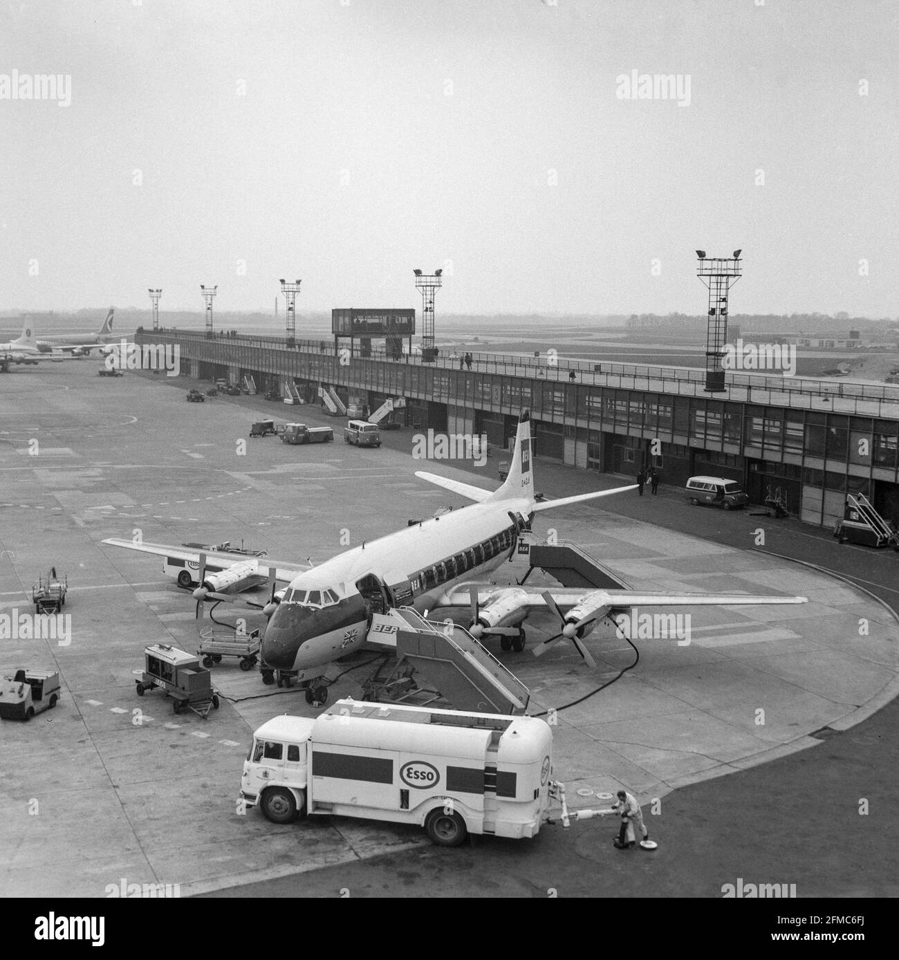 Vintage black and white photograph taken at Manchester Ringway Airport in England, on 11th April 1970, showing a BEA, British European Airways, Vickers Viscount airliner, registration G-AOJB. The aircraft is being refuelled by an Esso fuel tanker. Stock Photo