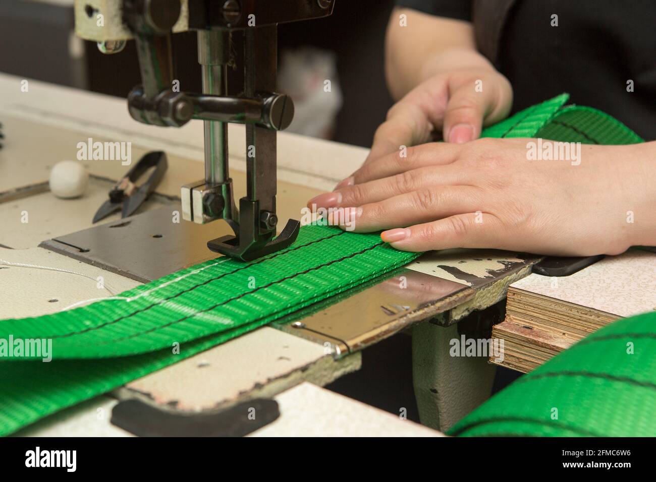 Industrial sewing machine sews a webbing sling. Manufacture of textile