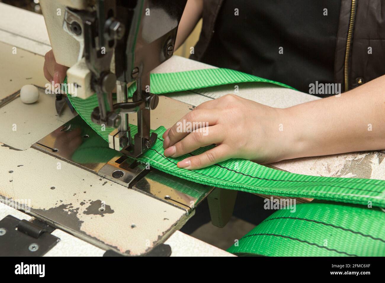 Industrial sewing machine sews a webbing sling. Manufacture of textile