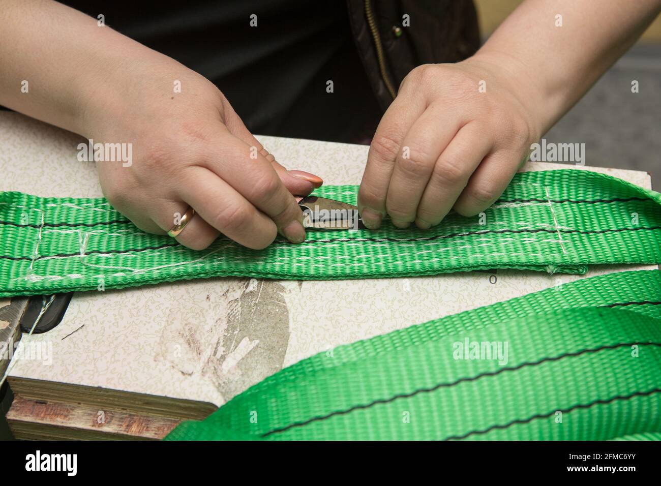 Industrial sewing machine sews a webbing sling. Manufacture of textile