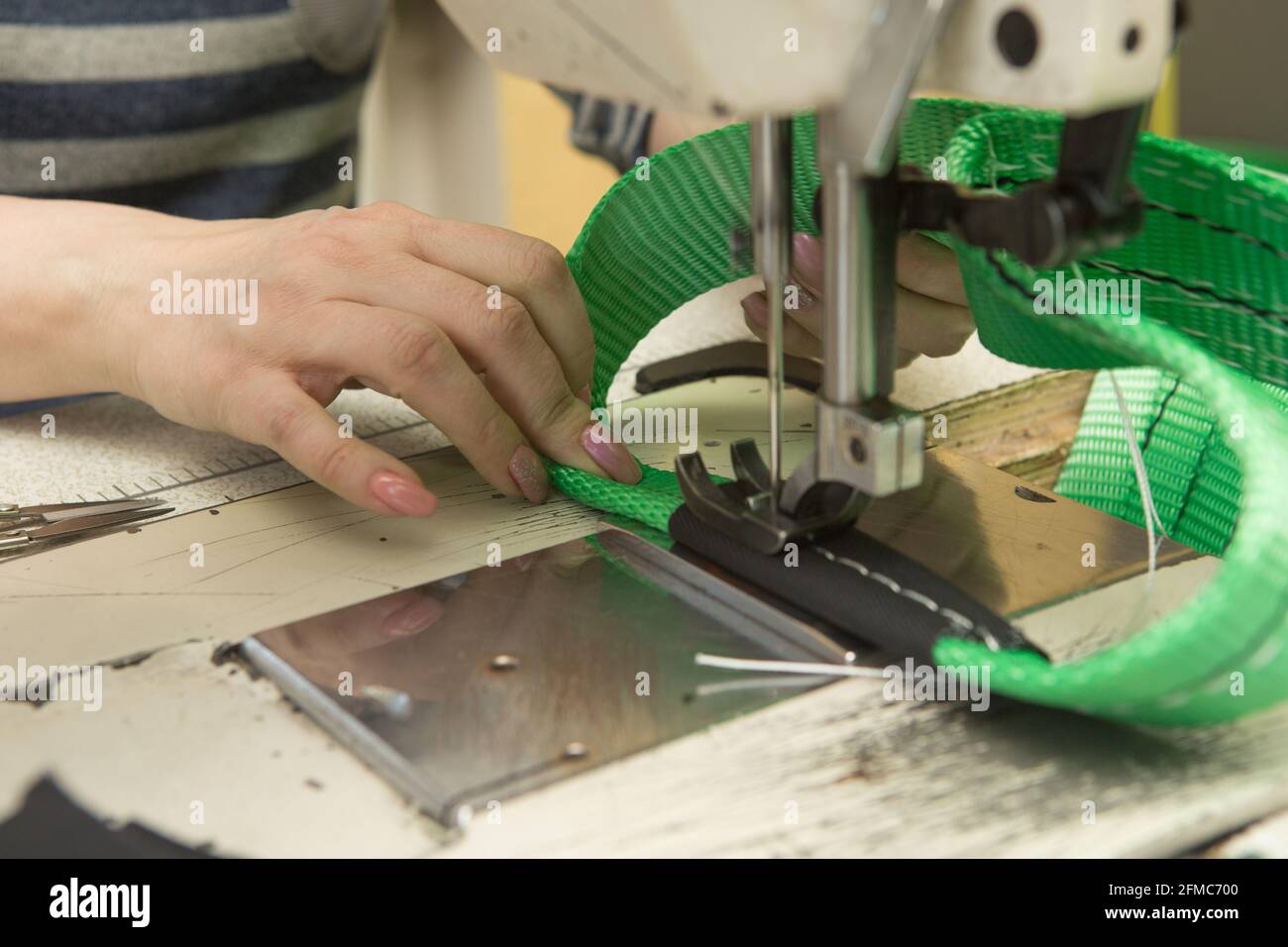 Industrial sewing machine sews a webbing sling. Manufacture of textile