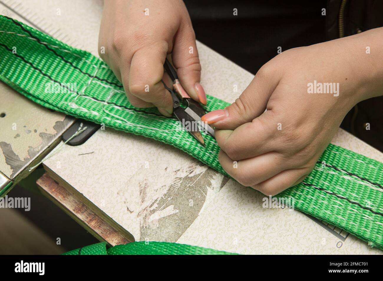 Industrial sewing machine sews a webbing sling. Manufacture of textile