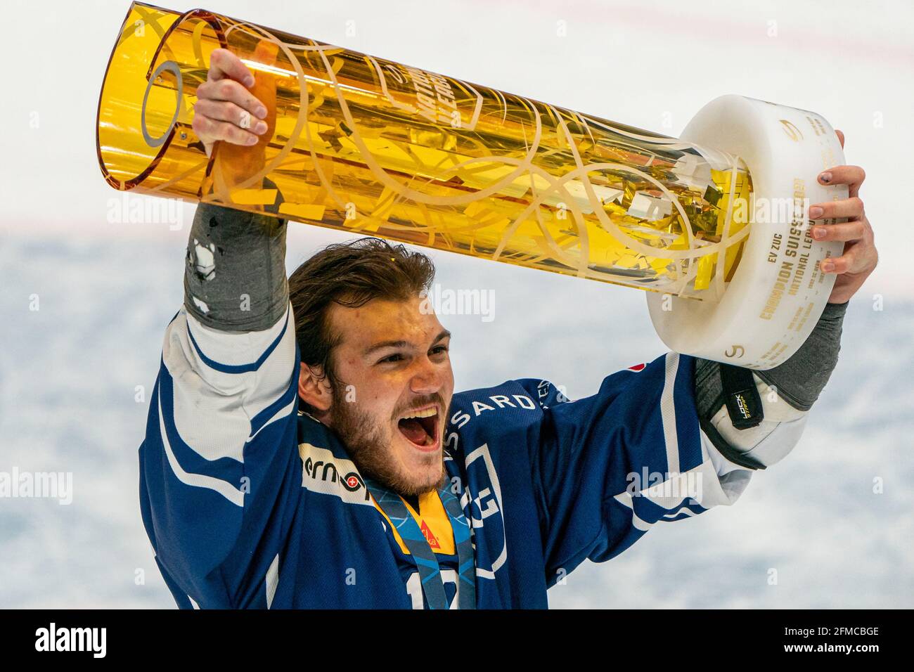 Yannick Zehnder # 12 (EV Zug) is happy with the championship trophy during  the National League Playoff Final ice hockey game 3 between EV Zug and  Geneve-Servette HC on May 7th, 2021