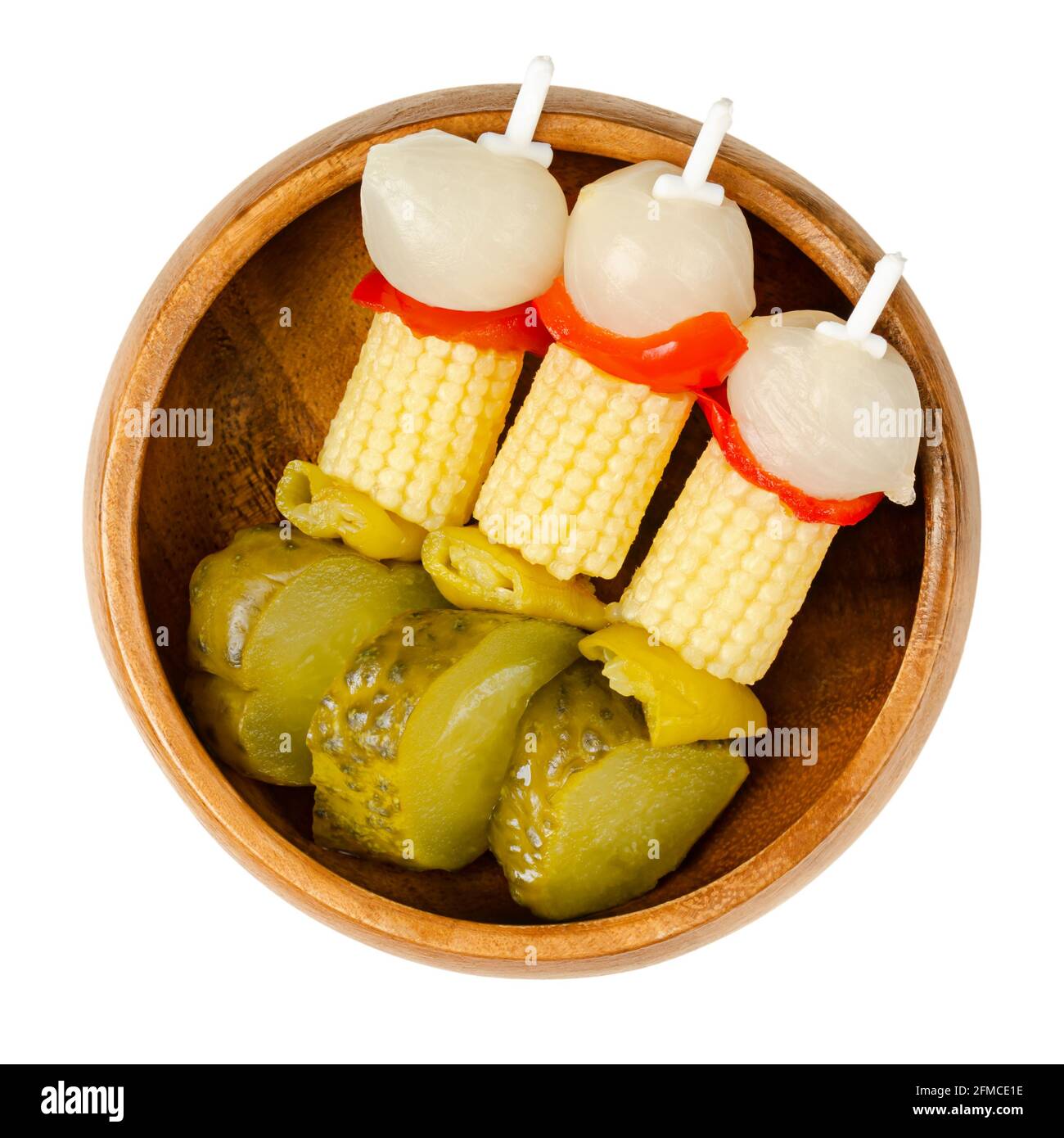 Vegetable party skewers in a wooden bowl. Pickled vegetables on plastic skewers. Pearl onions, red bell peppers, baby corn, green chilies and gherkins Stock Photo