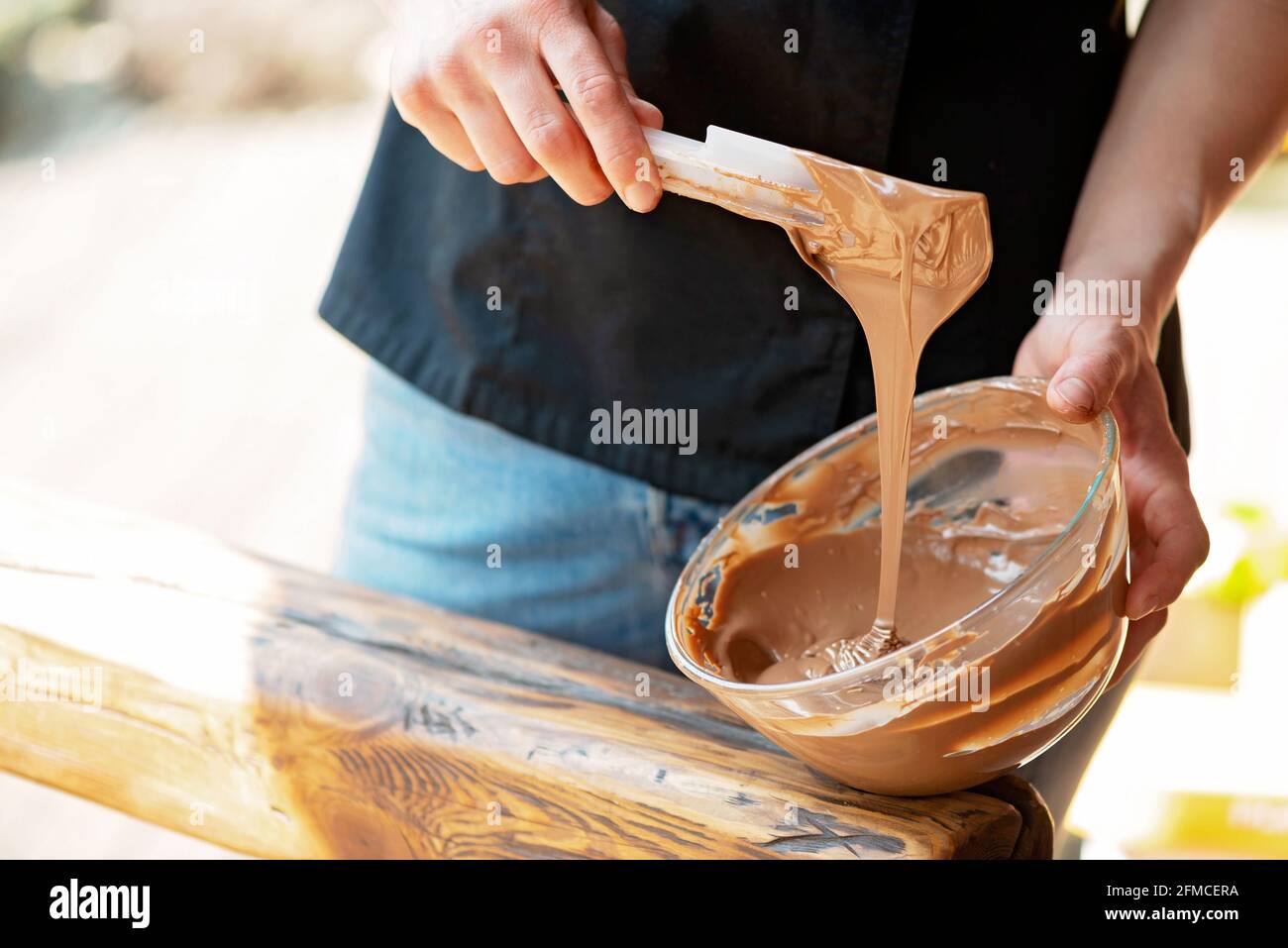 The pastry chef tempered hot milk chocolate. Cooking desserts. Soft selective focus. Stock Photo