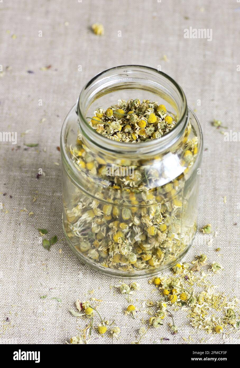 Chamomile herbal tea in chinese cup and glass jar with dry herb flowers, above overhead view, naturopathy, natural medicine, healing drinks for sleep, Stock Photo
