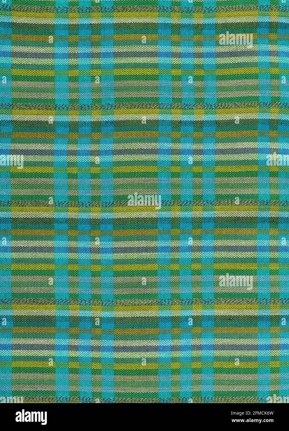 A flat area of woven fabric as a background texture and pattern in greens and blues Stock Photo