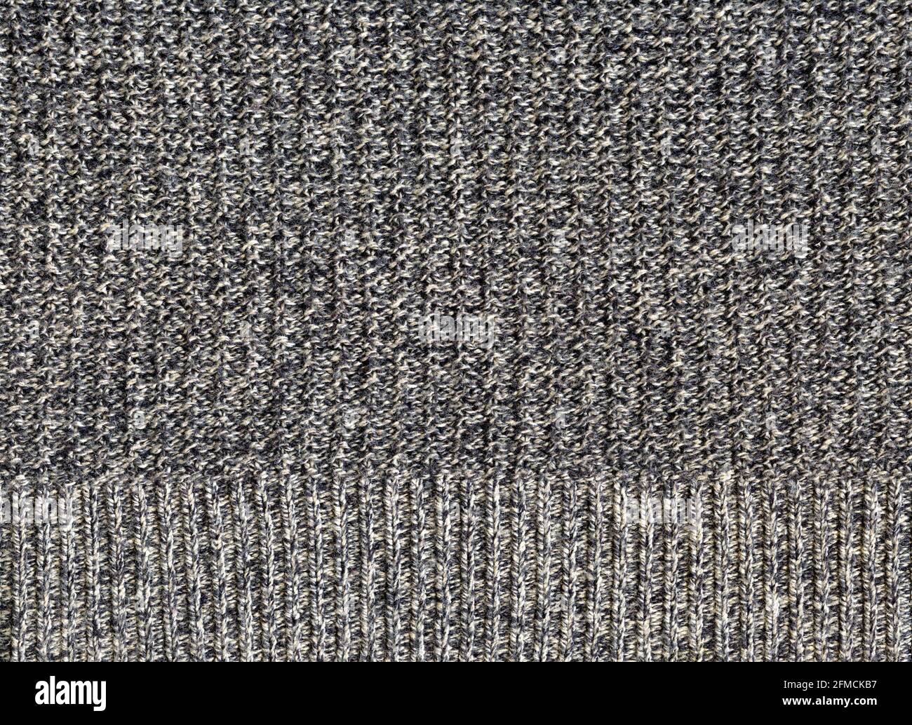 A flat section of knitted grey and white cotton including a border hem Stock Photo