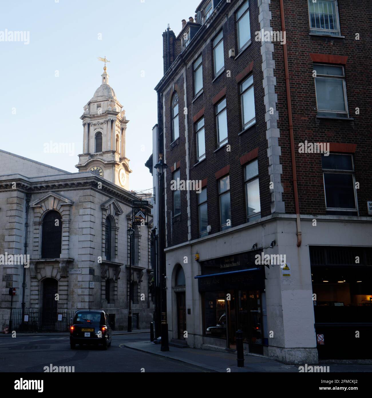 London, Greater London, England - May 04 2021: Taxi stops at a junction on Maddox Street in the evening outside of St George's Church Stock Photo