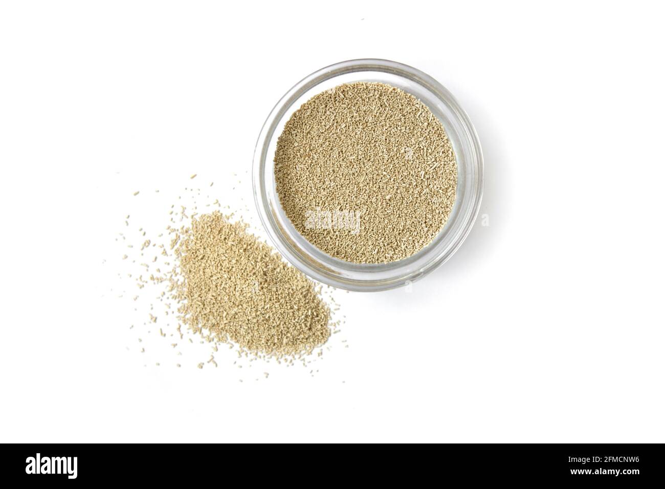 dry yeast in a glass bowl on a white isolated background, top view Stock Photo
