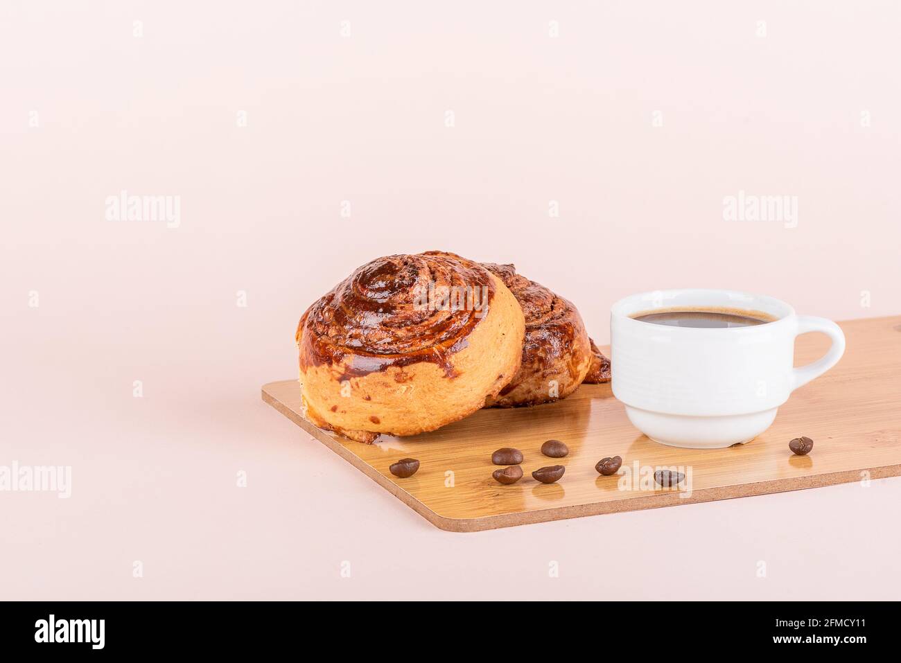 Two sweet cinnamon rolls and a cup of coffee. Homemade buns. Stock Photo