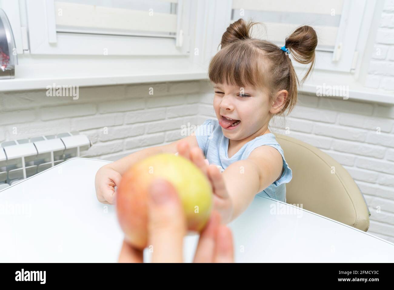 the child rejects the apple and chooses unhealthy sweets Stock Photo ...
