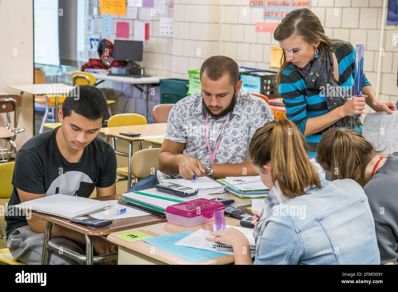 Teacher helping  high school students in the classroom Stock Photo