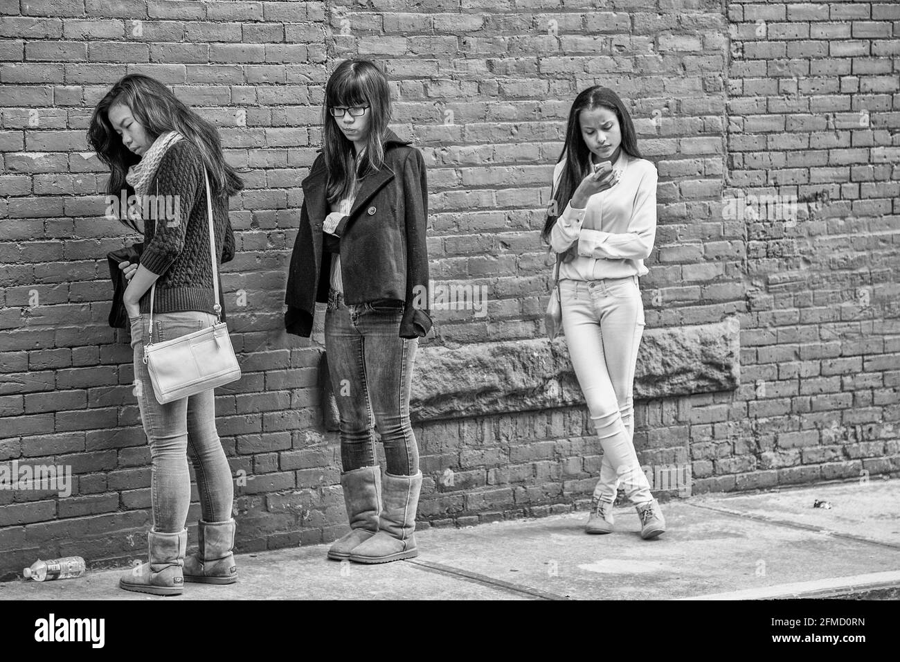Three girls waiting outside of the theater for the show to begin Stock Photo