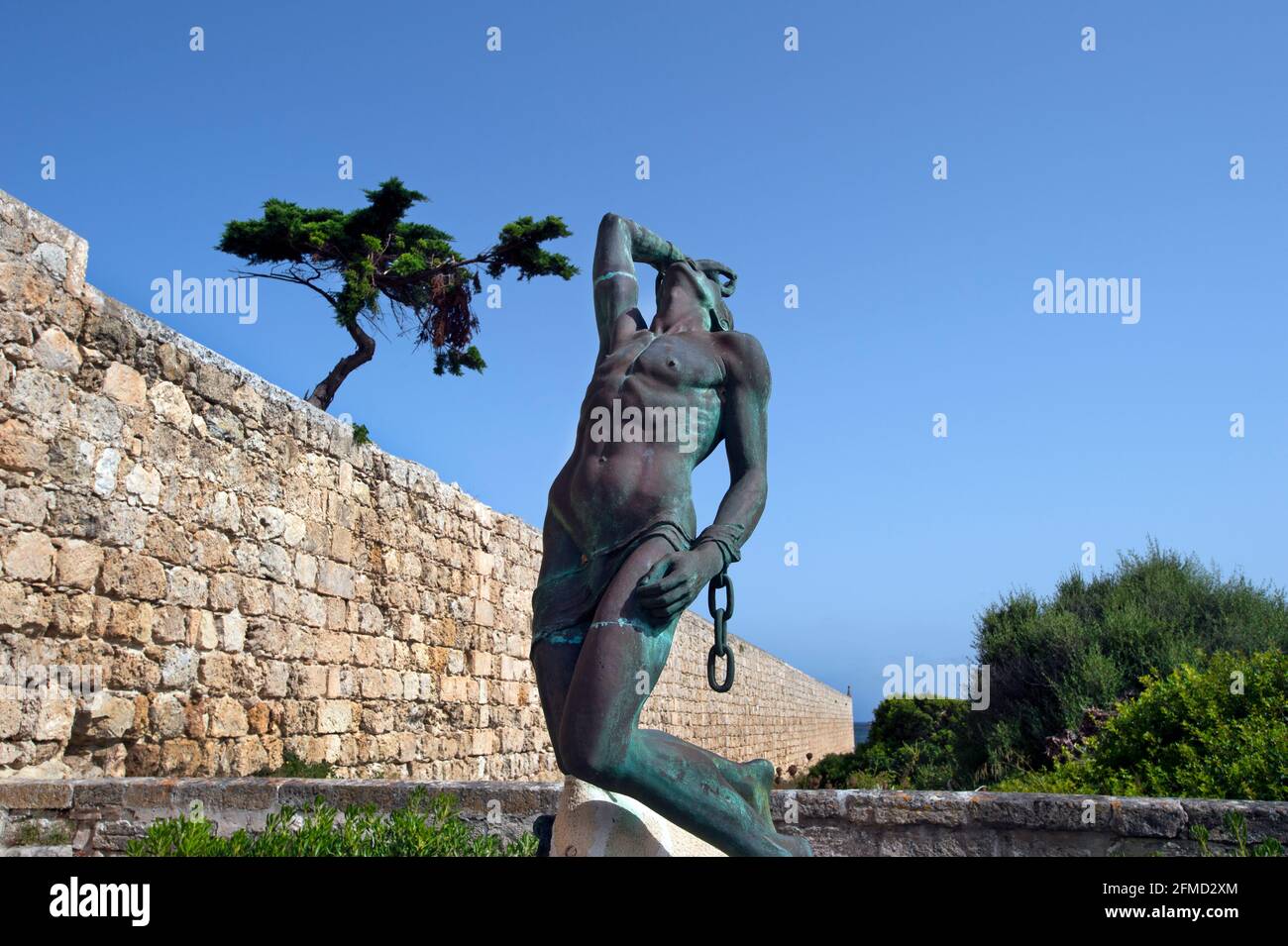 the bronze statue of the shackled man casting off his chains a symbol of freedom from slavery outside Lazareto museum in mahan harbour menorca Stock Photo