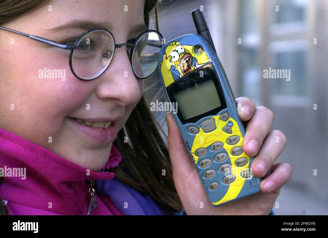 Zoya Giammetta, age 8, December 2000 with a Homer Simpson Nokia mobile phone.  (note: she is posing with the phone, and does not own one herself) Stock Photo