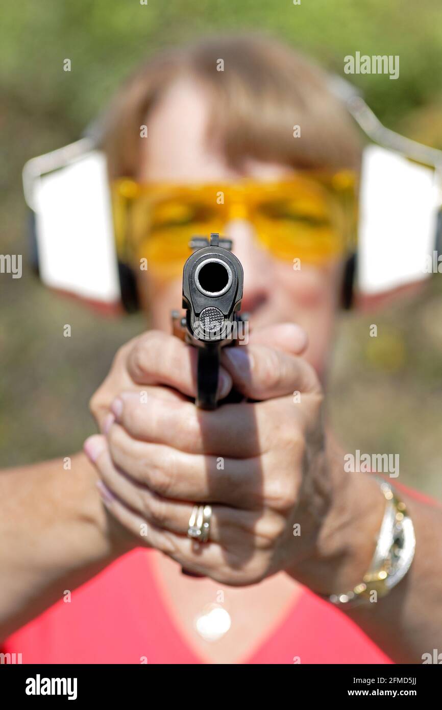 a woman shooting a 45 auto handgun at targets Stock Photo