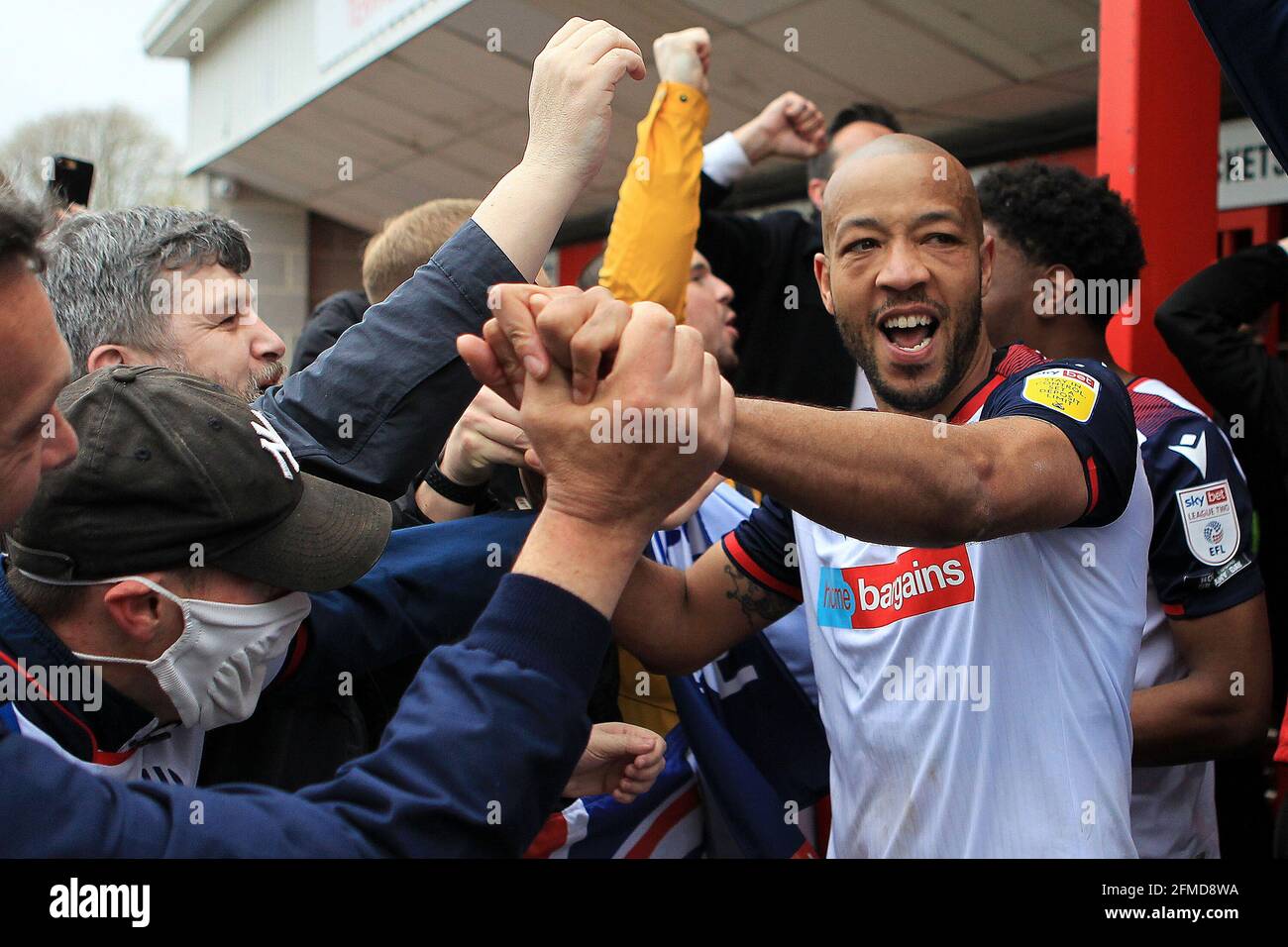Alex Baptiste  of Bolton Wanderers celebrates with the Bolton fans after their teams promotion to League One. EFL Skybet Football league two match, Crawley Town v Bolton Wanderers at the People's Pension Stadium in Crawley, West Sussex, England on Saturday 8th May 2021. this image may only be used for Editorial purposes. Editorial use only, license required for commercial use. No use in betting, games or a single club/league/player publications.pic by Steffan Bowen/Andrew Orchard sports photography/Alamy Live News Stock Photo