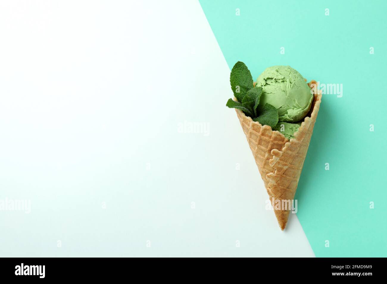 Cone of mint ice cream on two tone background Stock Photo - Alamy