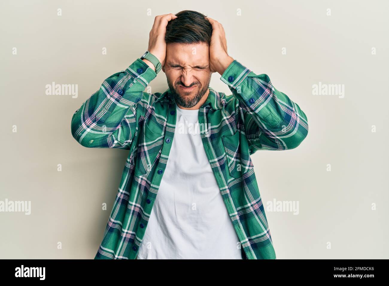 Handsome man with beard wearing casual clothes suffering from headache ...