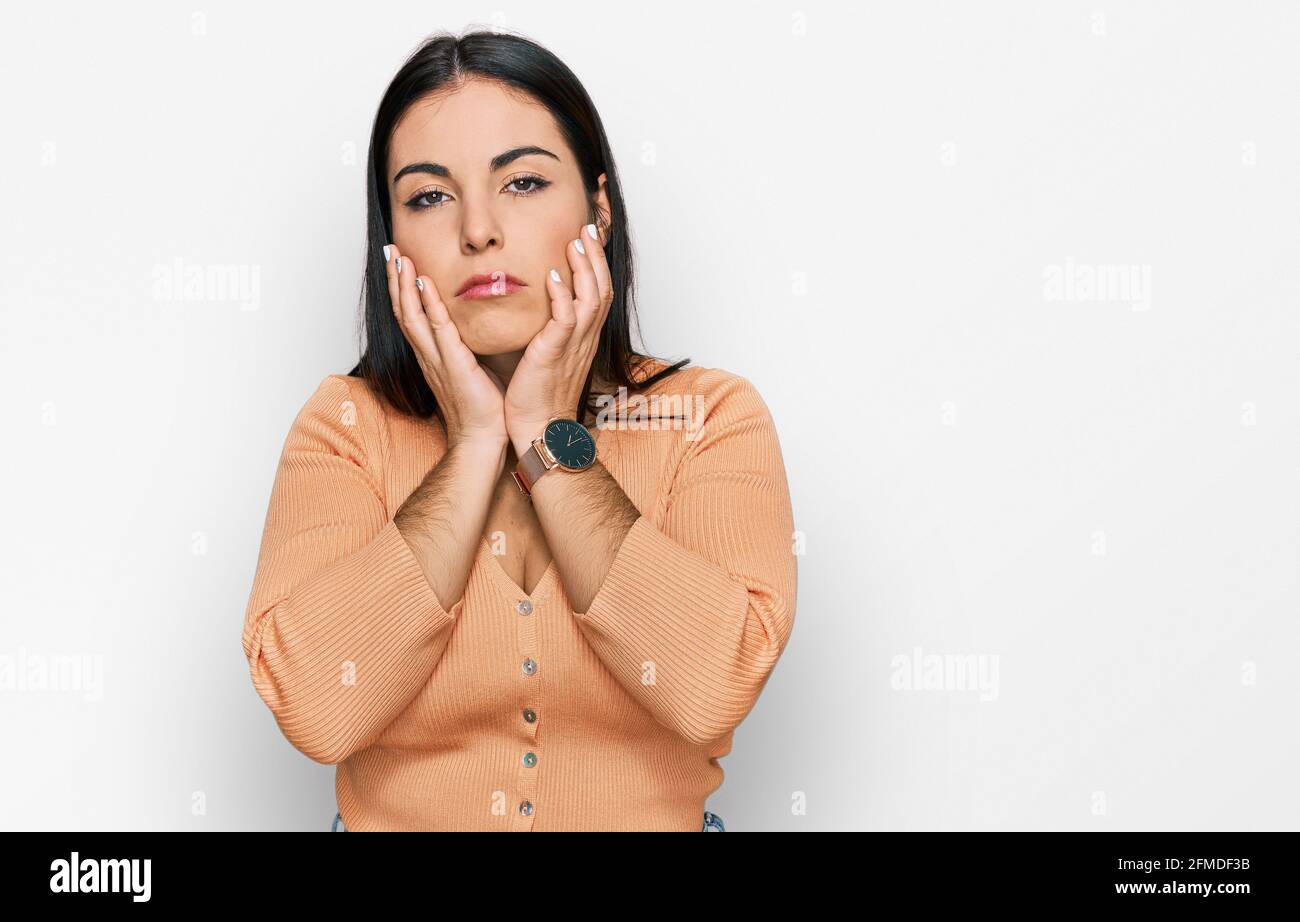 Young hispanic woman wearing casual clothes tired hands covering face, depression and sadness, upset and irritated for problem Stock Photo