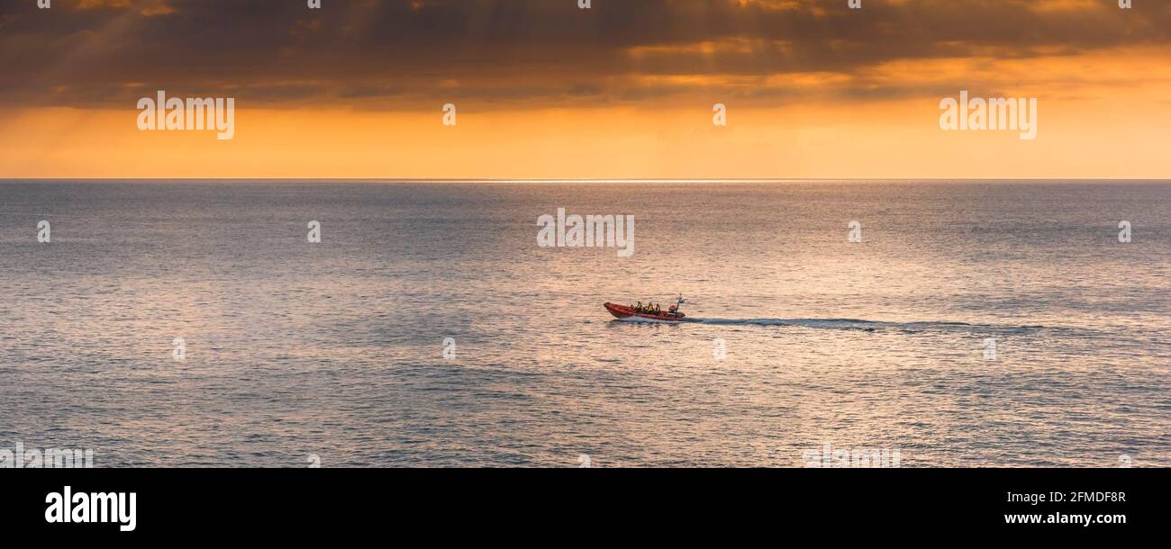 A panoramic image of the Newquay RNLI Atlantic 85 class inshore lifeboat Gladys Mildred speeding to Fistral Bay on an emergency call out in Cornwall. Stock Photo