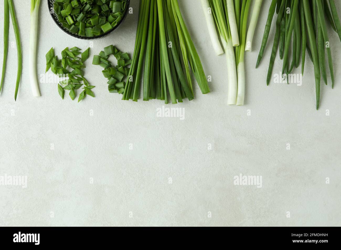 Fresh green onion on white textured background Stock Photo - Alamy