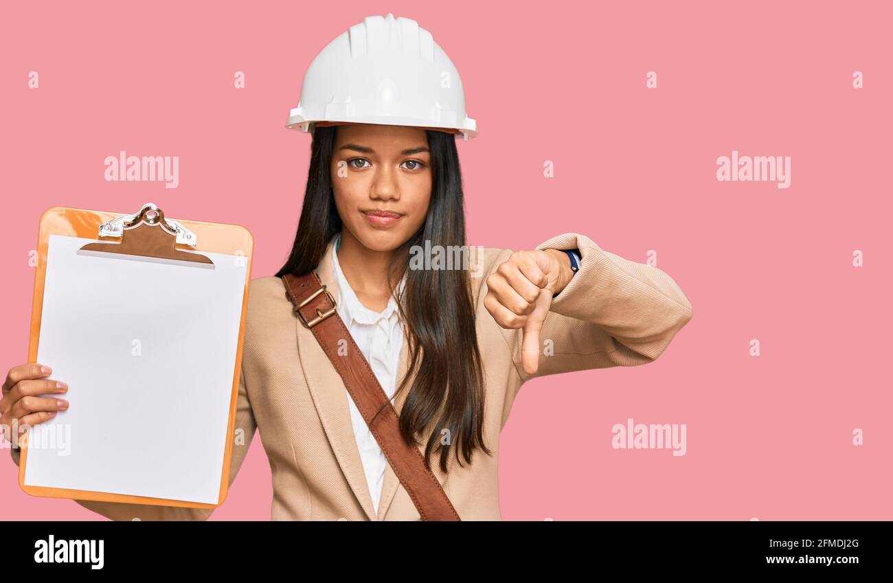 Beautiful hispanic woman architect showing black space on clipboard ...