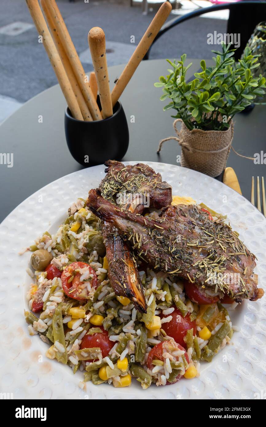 Sisteron, France - July 7, 2020: A local specialty in Sisteron is lamb with honey and Provencal salad with rice and vegetables Stock Photo