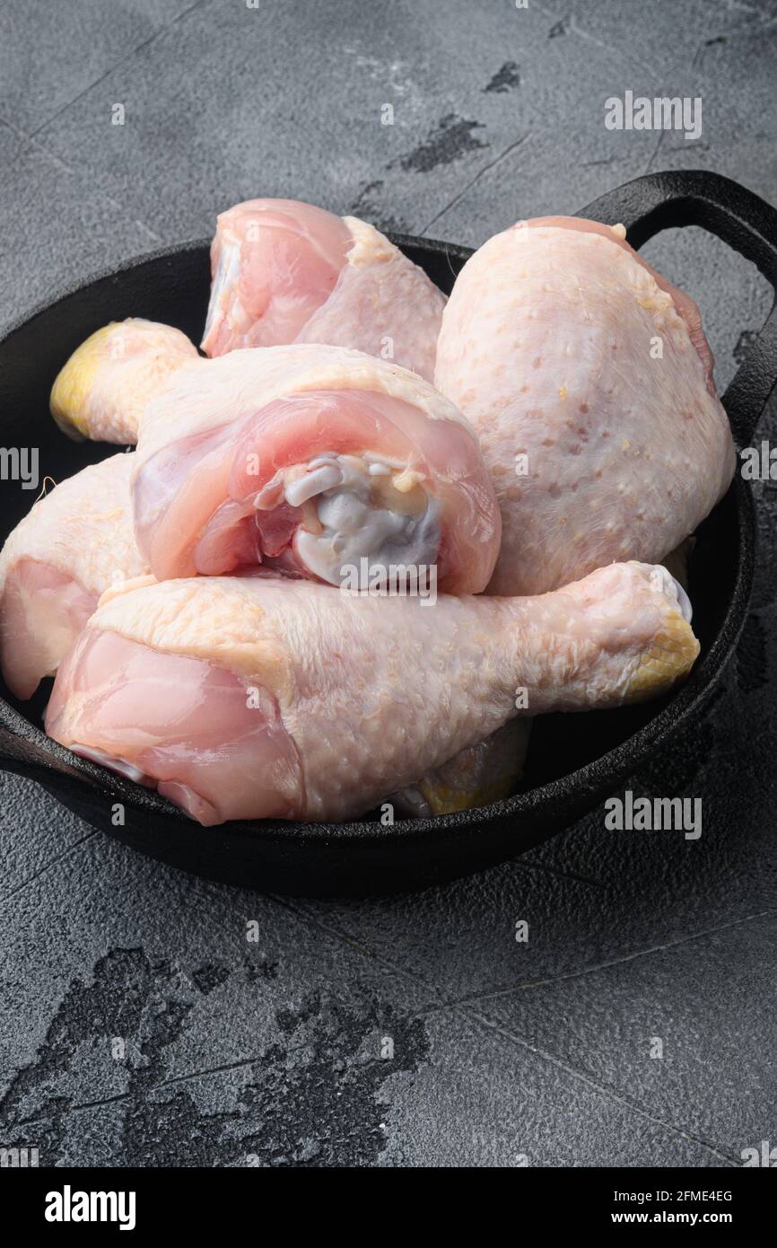 Uncooked Chicken Thigh or legs, drumsticks set, in frying cast iron pan