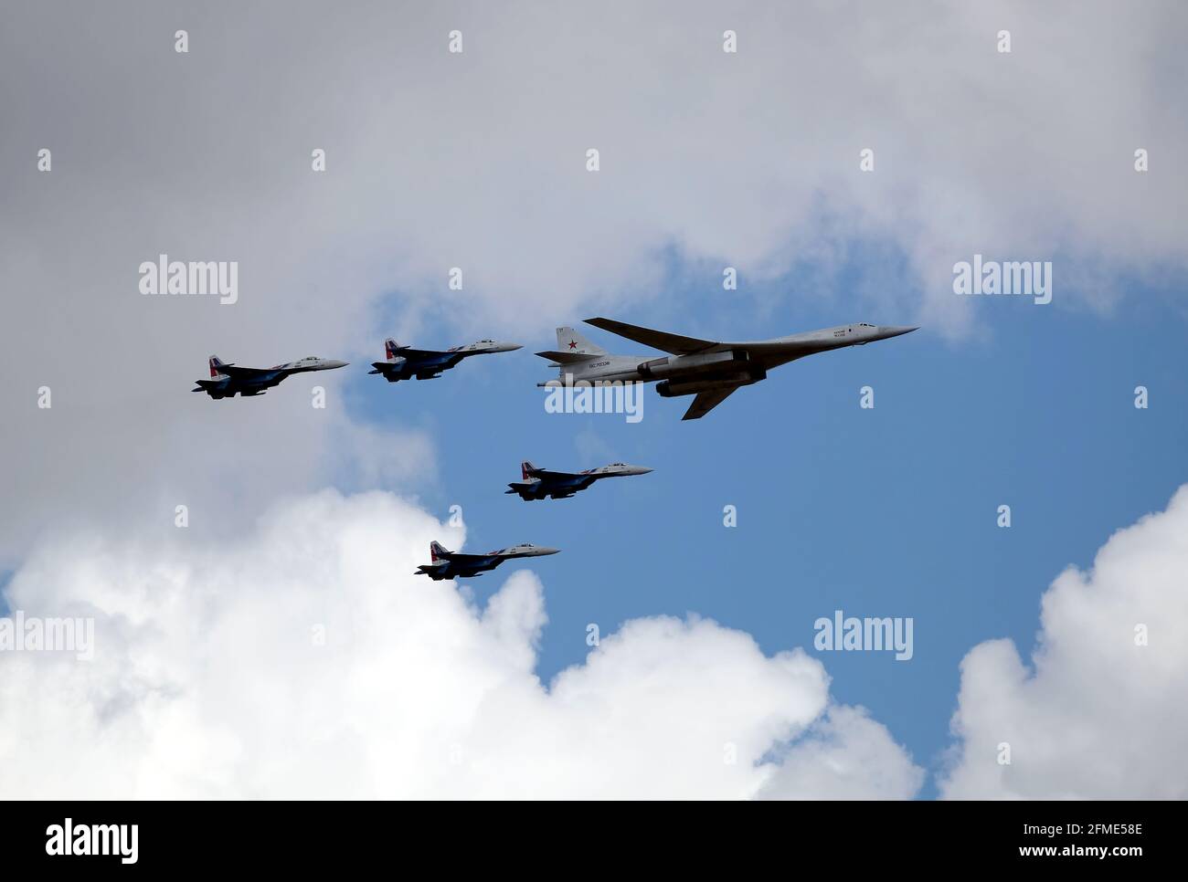 MOSCOW, RUSSIA - May 7, 2021: Russian military Supersonic bomber-missile carrier TU-160 White Swan and four SU-35S fighters following on the sides Stock Photo