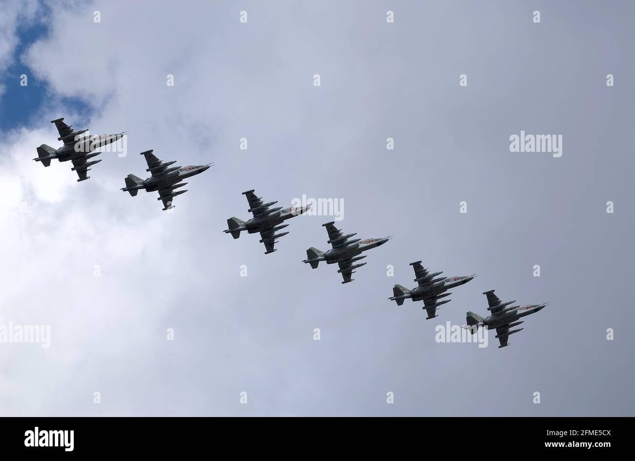 MOSCOW, RUSSIA - MAY 7, 2021: Group of six Russian military tactical frontline bombers SU-25 Frogfoot fast flying on parade rehearsal in cloudy sky Stock Photo