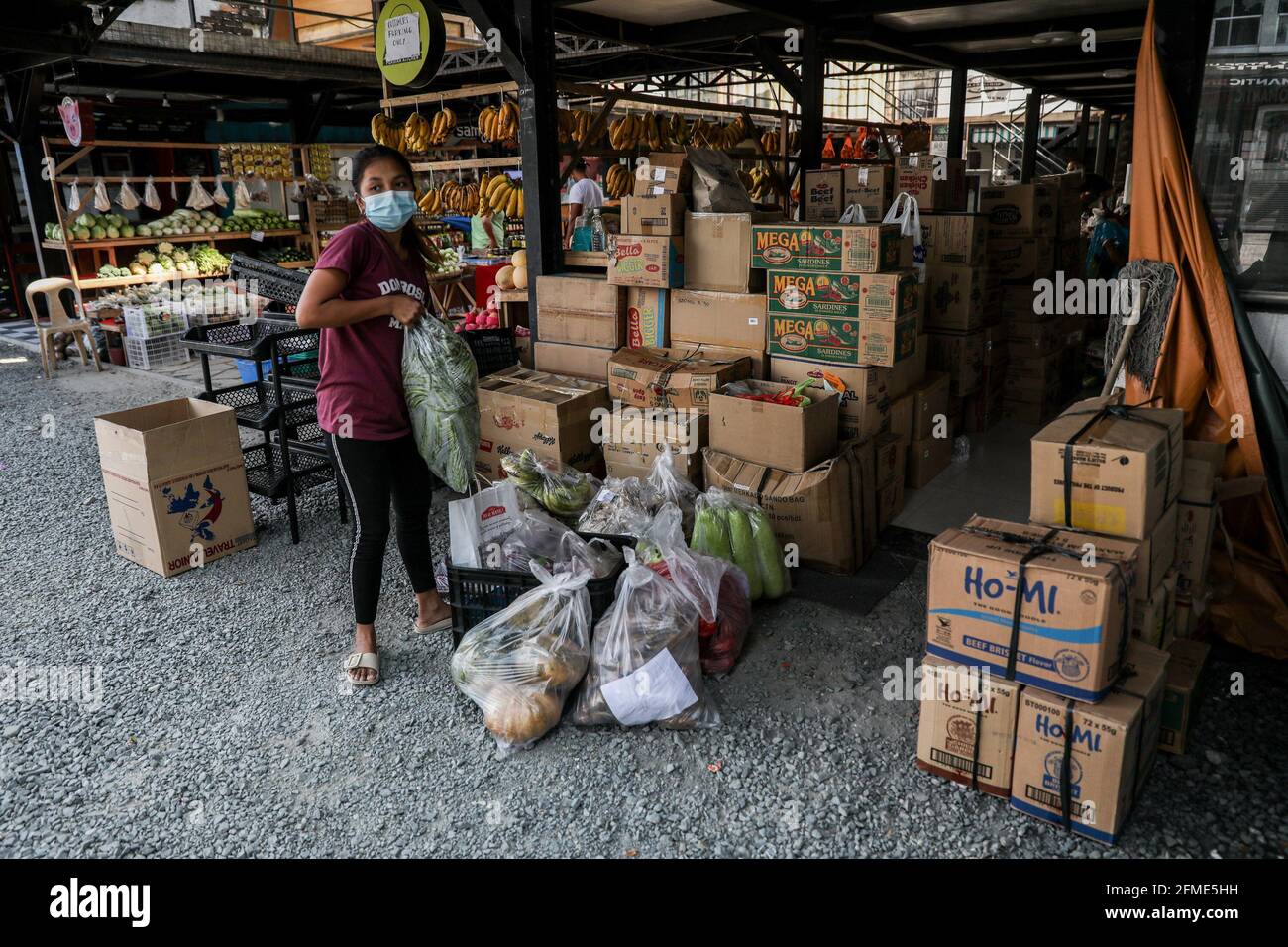 Volunteers prepare food donations at a community pantry in the Maginhawa neighborhood in Quezon City. Despite allegations by law enforcers as communist underground organizations that want to undermine the government, community pantries have sprouted across the country in the past week to help people affected by strict quarantine measures to curb the spread of the coronavirus disease. Metro Manila, Philippines. Stock Photo