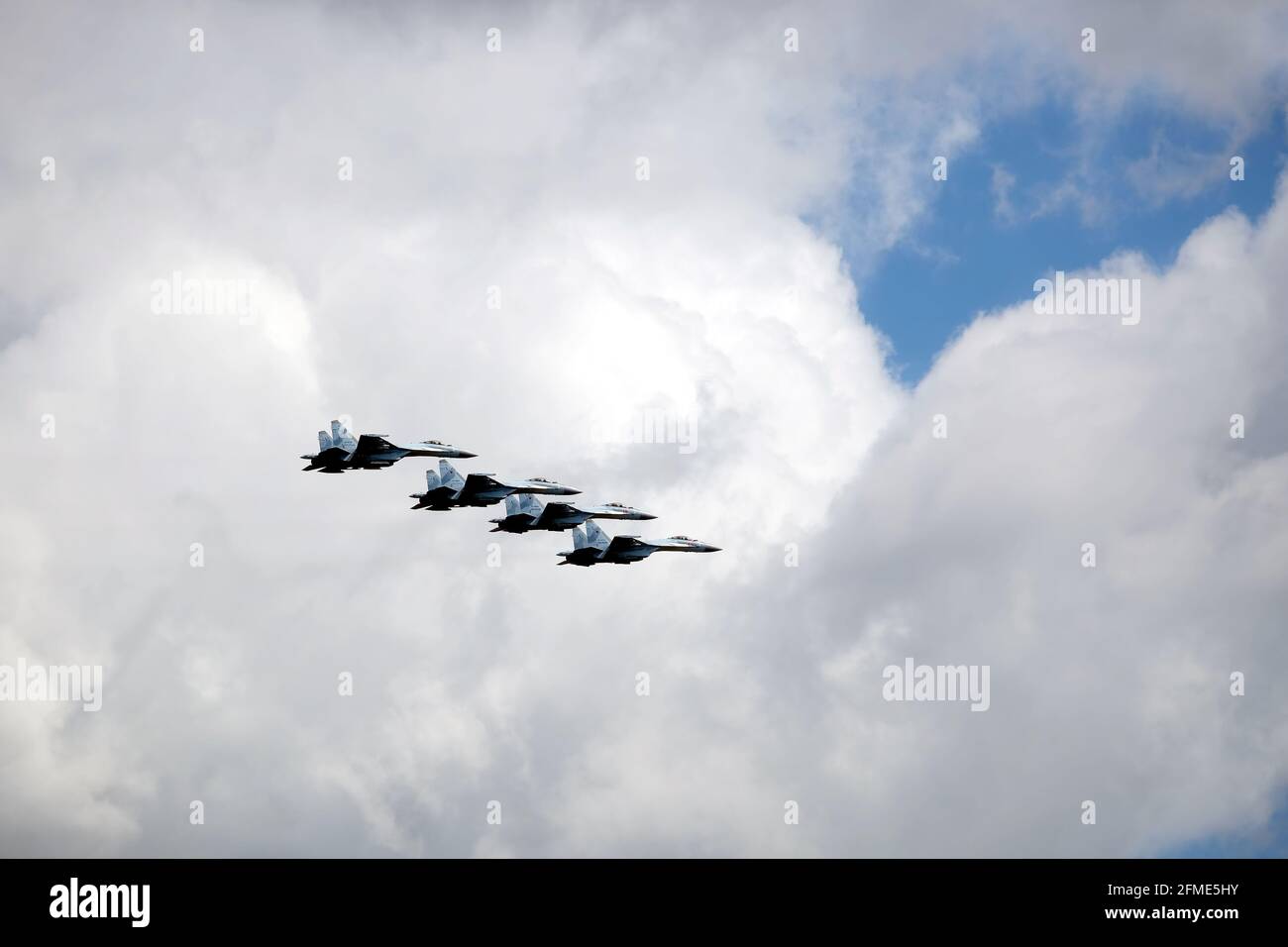 MOSCOW, RUSSIA - MAY 7, 2021: Group of four Russian military supersonic high-altitude interceptors SU-35 in flight on parade rehearsal in cloudy sky Stock Photo