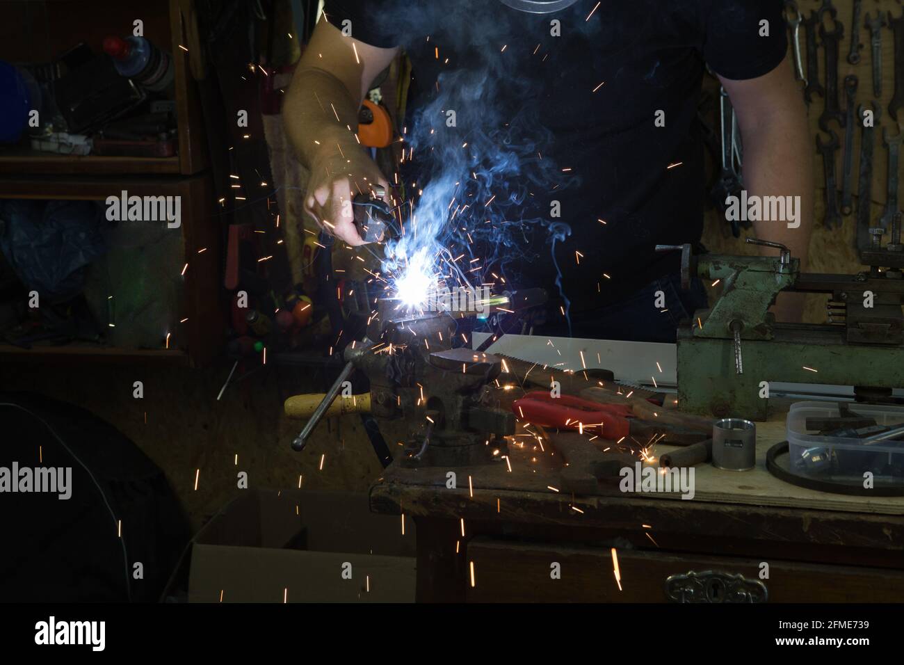 Man Using Wielding Machine Working with the tool. Hands of a young man working with a welding ...