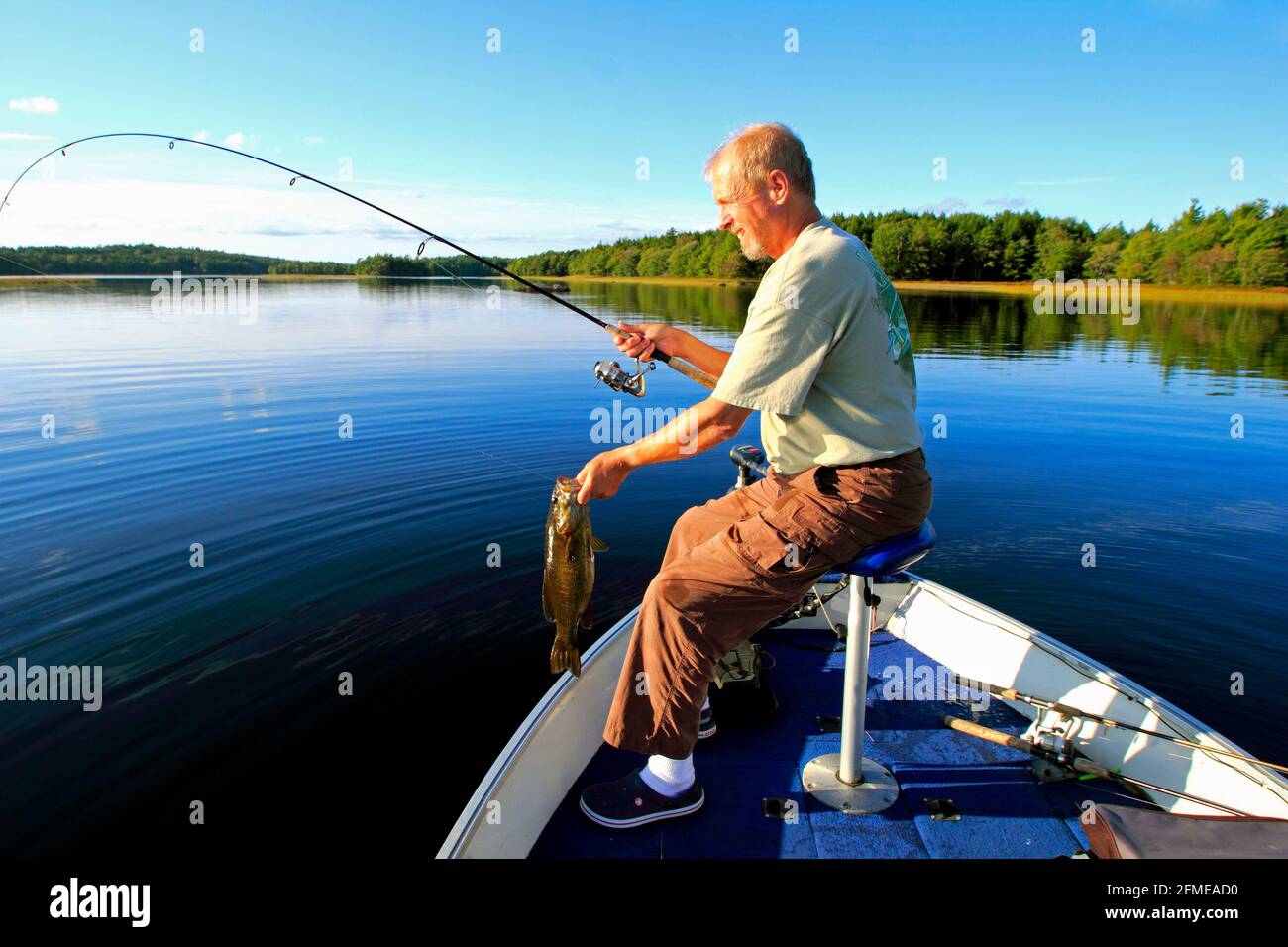 A fisherman holding a smallmouth bass Stock Photo
