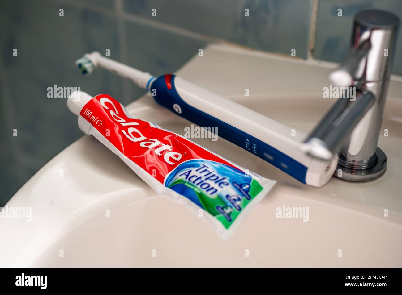 Close up and selective focus on a tube of Colgate toothpaste and an  electric Oral B toothbrush on a white sink in the bathroom Stock Photo -  Alamy