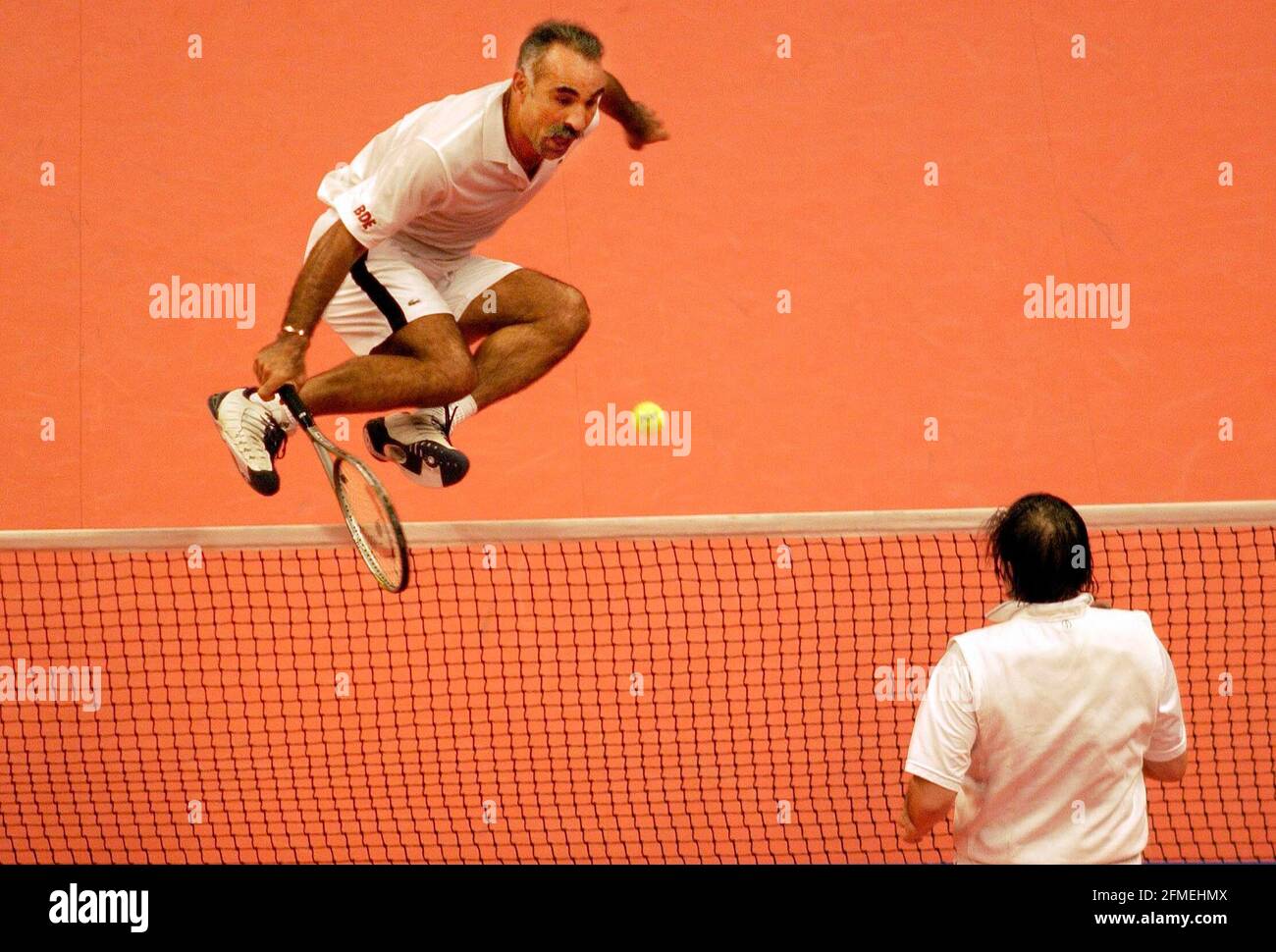 THE HONDA CHALLENGE AT THE ROYAL ALBERT HALL 6/12/2002 MANSOUR BAHRAMI & CHRIS WILKINGSON V J.BATES & NASTASE. BAHRAMI JUMPS THE NET AND PLAYS THE BACK INTO HIS HALF OF THE COURT. PICTURE DAVID ASHDOWN.TENNIS Stock Photo