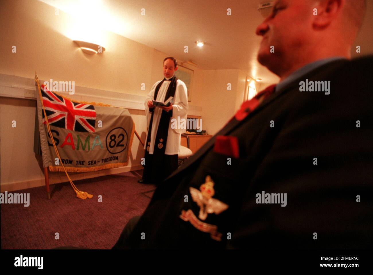 Falklands House Service November 1998      The Reverend Phil Parker dedicating the standard for SAMA 82, at Falklands House in London, in front of a group including Falkland Vets and SAMA 82 Representatives. Man in foreground is Ieuan Bullivant, who is a Falklands vet., he was a Corporal and fought at Mount Longdon. Stock Photo