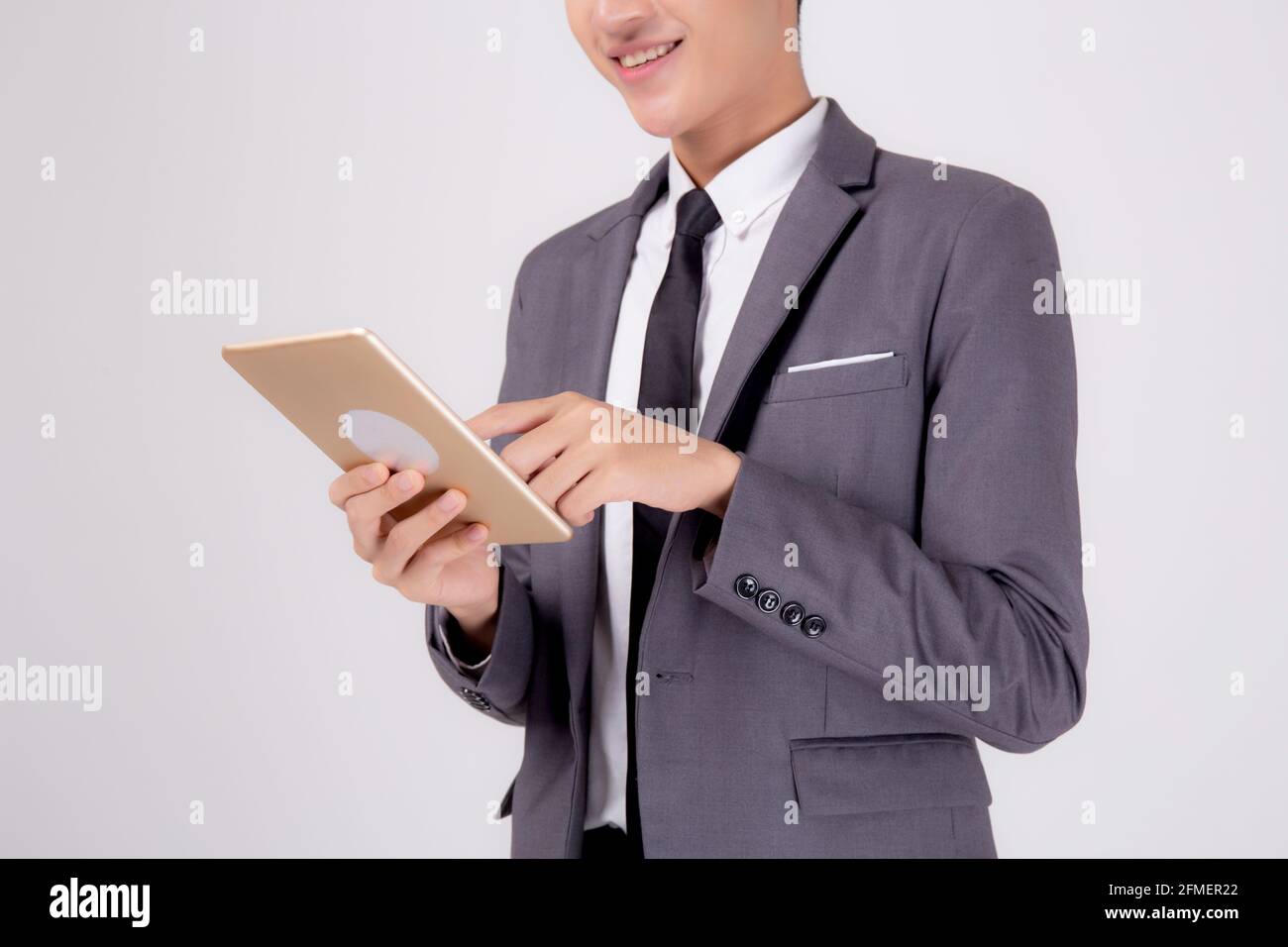 Portrait young asian business man in suit standing using tablet ...