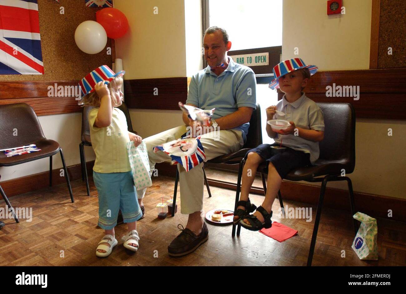 A parent at the Chandos Centre in Stratford with his two children at the end of a busy day celebrating the Queen's Golden Jubilee.3 June 2002 photo Andy Paradise Stock Photo