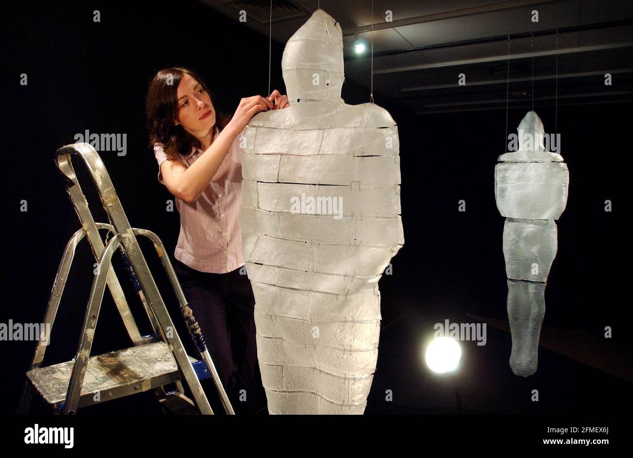 Exhibition Organiser Julia Davies checking over the finished glass installation entitled 'Brick Man' by artist Max Jacquard. The work is part of the 'Solid Air' exhibition, opening at the Crafts Council Gallery on Thursday 11th April.5 April 2002 photo Andy Paradise Stock Photo