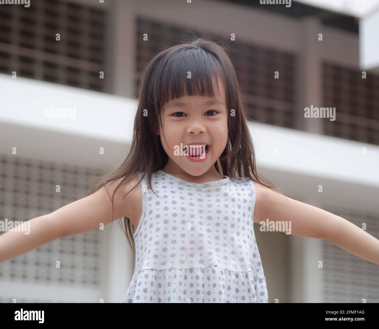 Happy little child girl having fun to play on home backyard. Stay at home to quarantine from coronavirus pandemic. Stock Photo